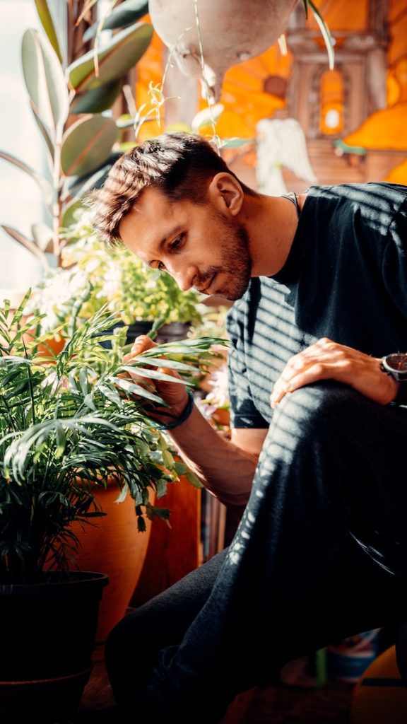 A guy tends to his indoor plants