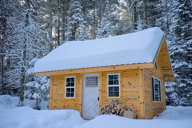 Snow-covered tiny house in the forest