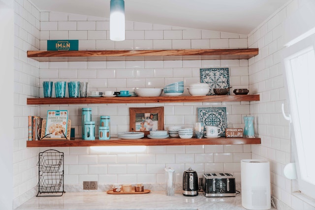 Open wooden shelving in the kitchen with a variety of cooking accessories and kitchen utensils on display