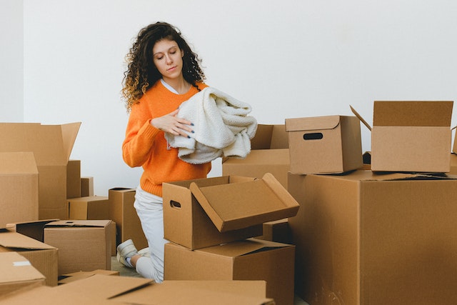 A woman putting away unwanted clothes in empty  boxes
