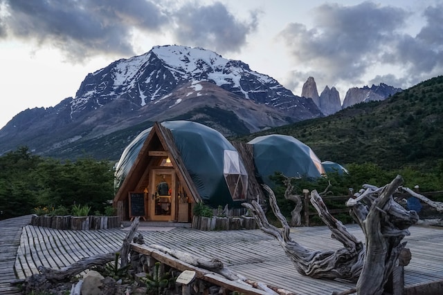 A group of round-roofed tiny houses near a snowcapped mountain