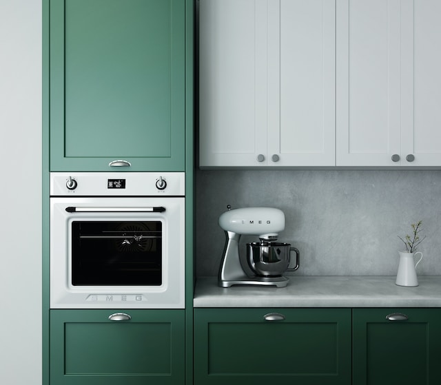 A kitchen showcasing an oven integrated into its green cabinetry