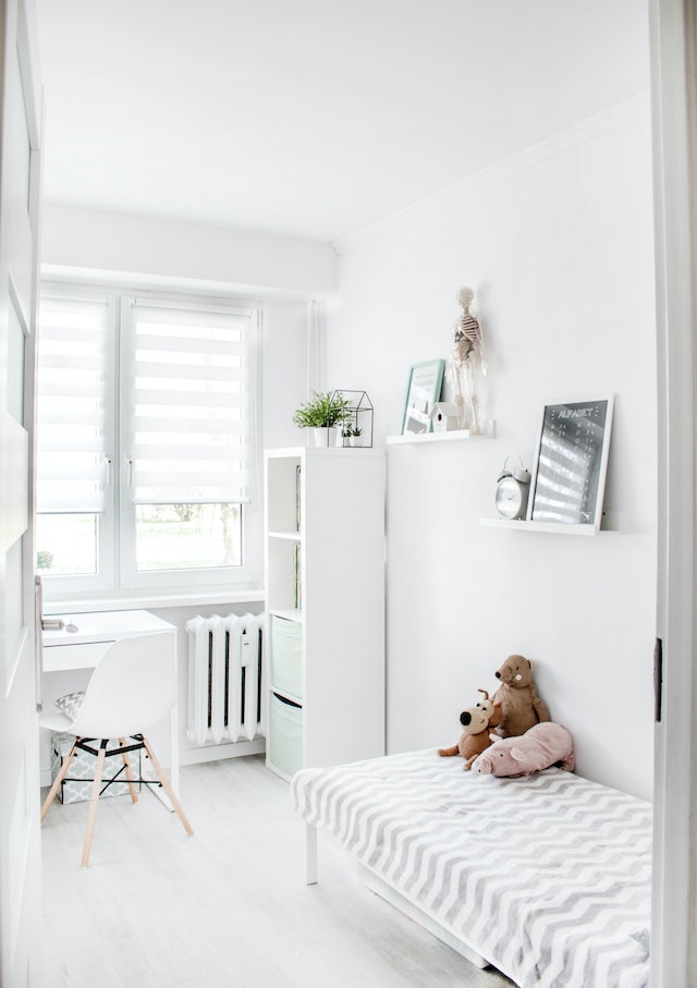 A white-themed kid's bedroom, bathed in natural light