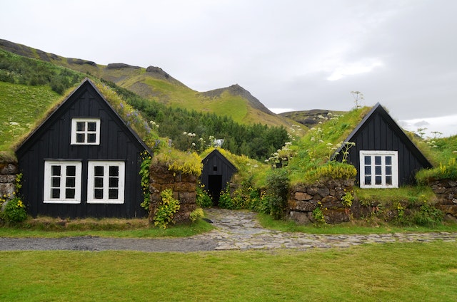 Tiny black houses on a grassy hillside
