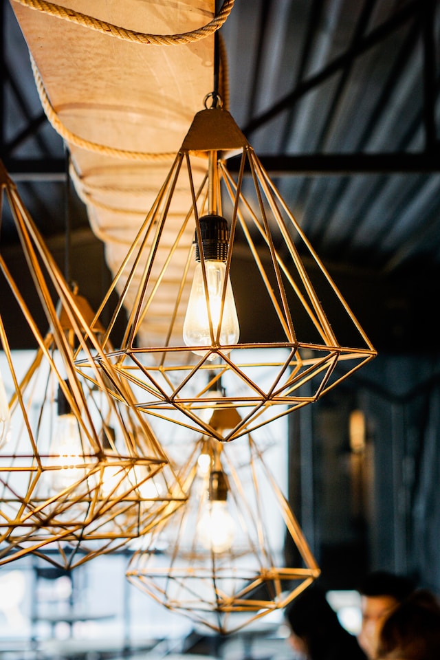Geometrical pendant lights hang from a ceiling