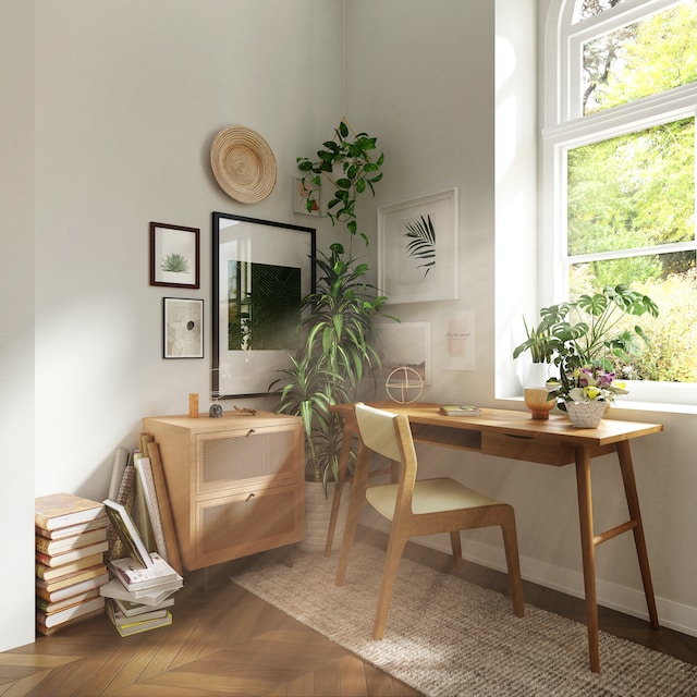 A home office setup right next to a bright window with lots of natural light streaming in